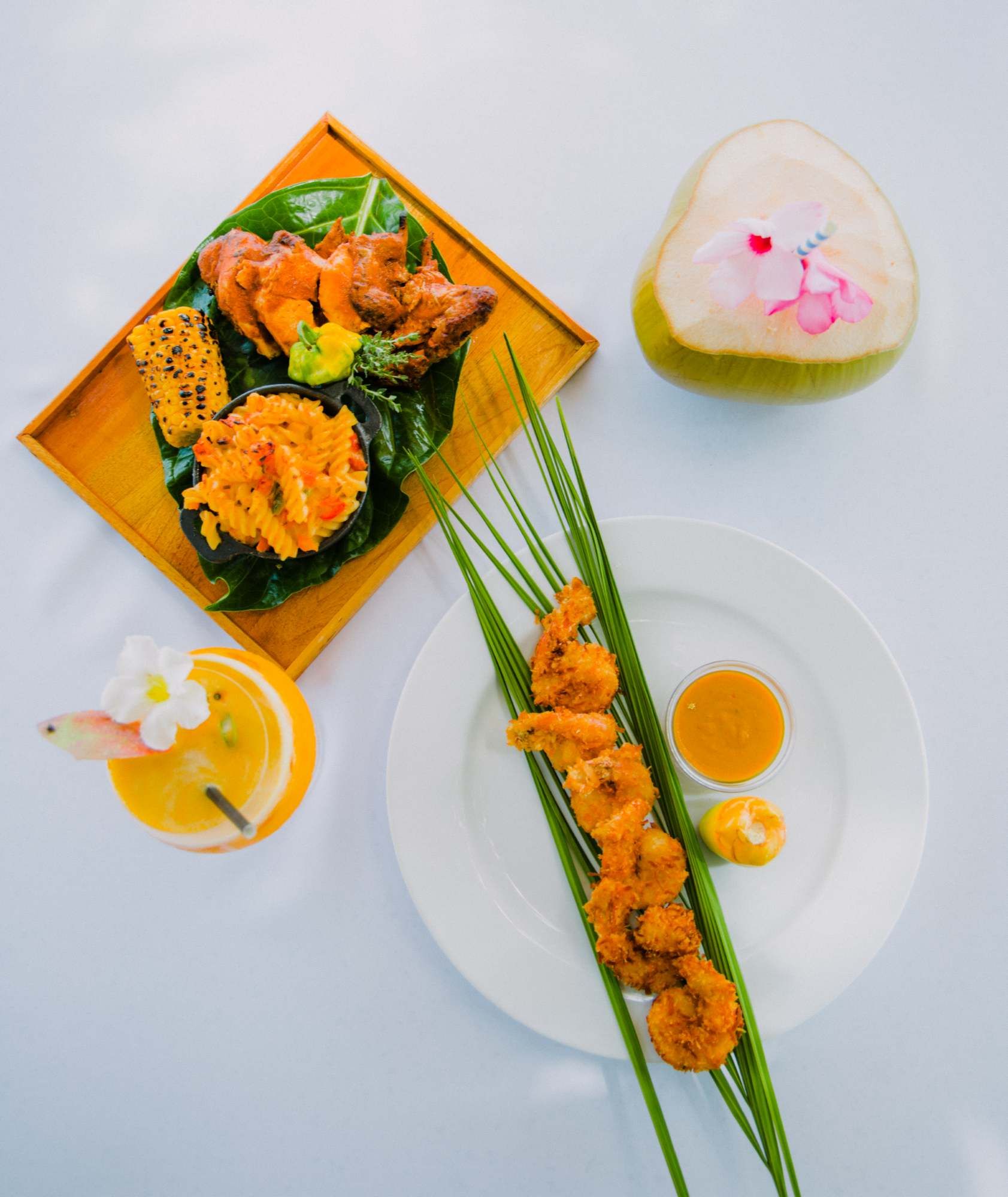 Plate with fried meat skewers, shredded salad, dipping sauce, and a decorative egg/flower arrangement on the side.