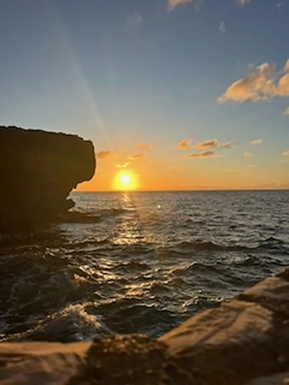 The sun setting over the Caribbean Sea beside the cliffs of Negril's West End.